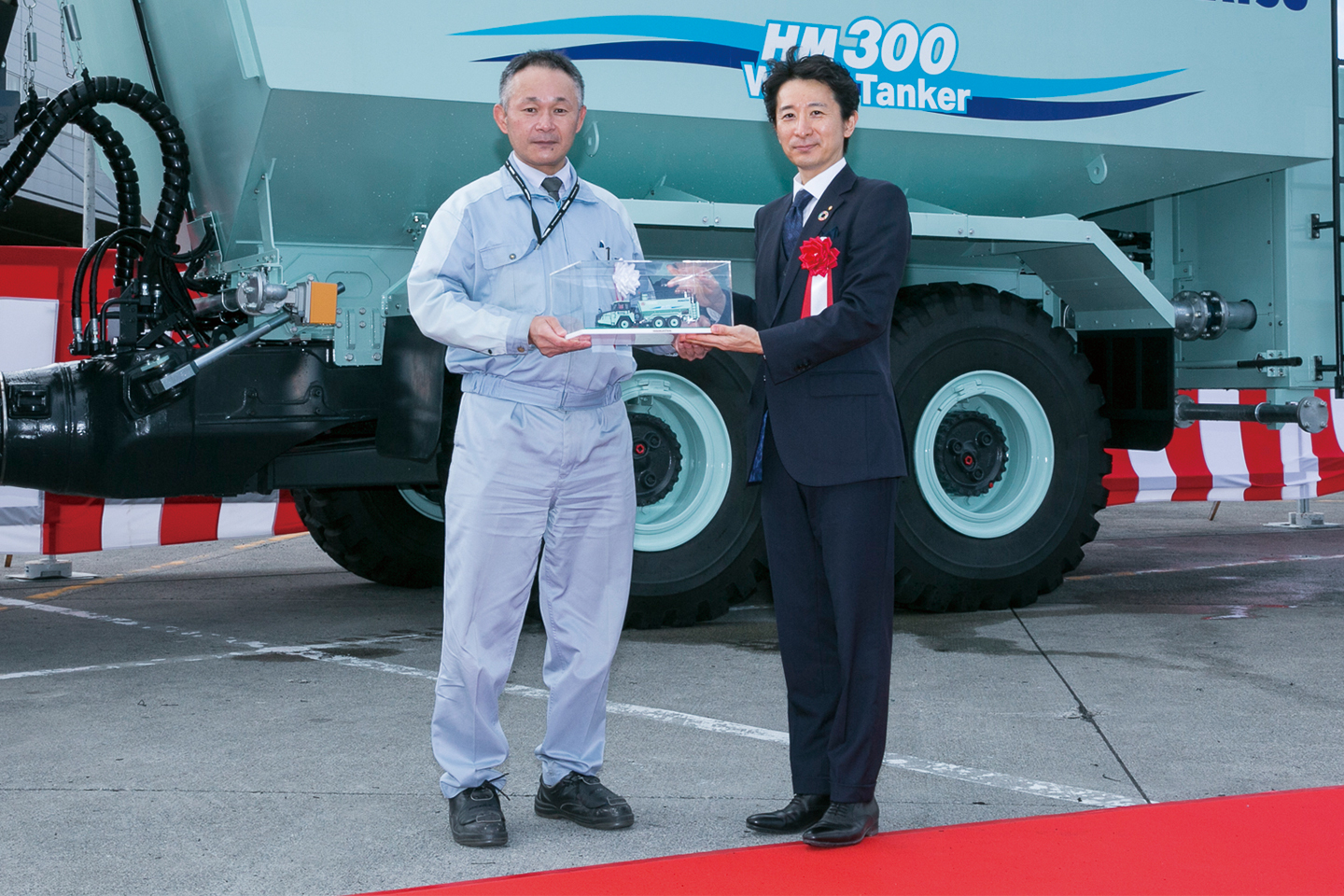 生産本部茨城工場 櫻井工場長から菊池社長へ、 記念品となるHM300-5散水車のミニチュアを進呈